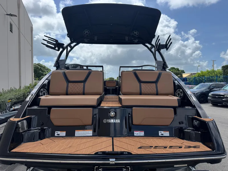 Slide: The Image of 2025 Yamaha Boats 255XD with luxurious seating and sleek design under a cloudy sky. - 3