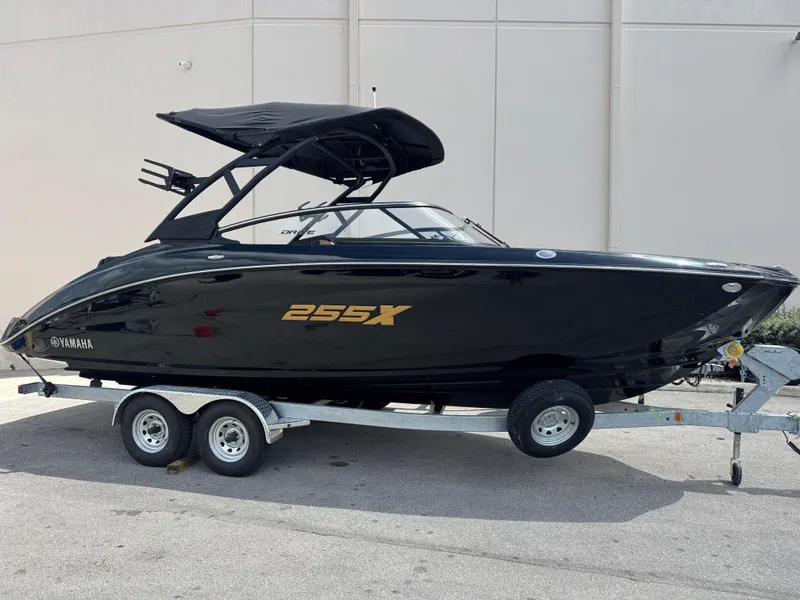 The Image of 2025 Yamaha Boats 255XD in black on trailer, side view. - 0