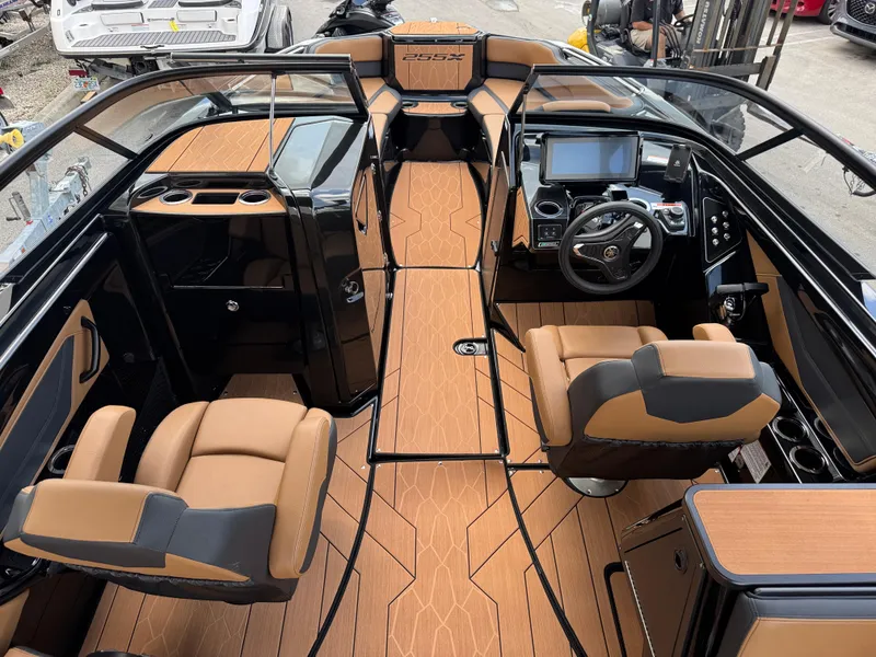 Slide: The Image of 2025 Yamaha Boats 255XD interior with tan and black seating, modern dashboard, and sleek design. - 12