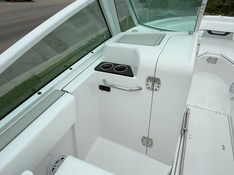 Slide: The Image of 2026 Blackfin 232 DC boat interior with cup holders and sleek white design. - 14