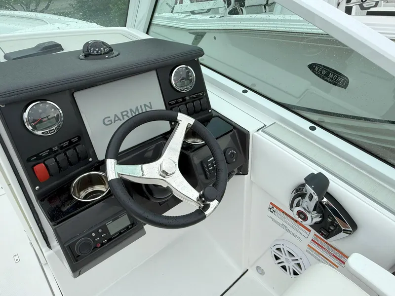 Slide: The Image of 2026 Blackfin 232 DC boat dashboard with Garmin navigation and steering wheel. - 16