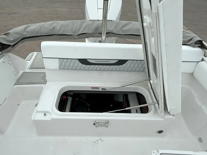 Slide: The Image of 2026 Blackfin 232 DC boat with open storage compartment and cushioned seating. - 19