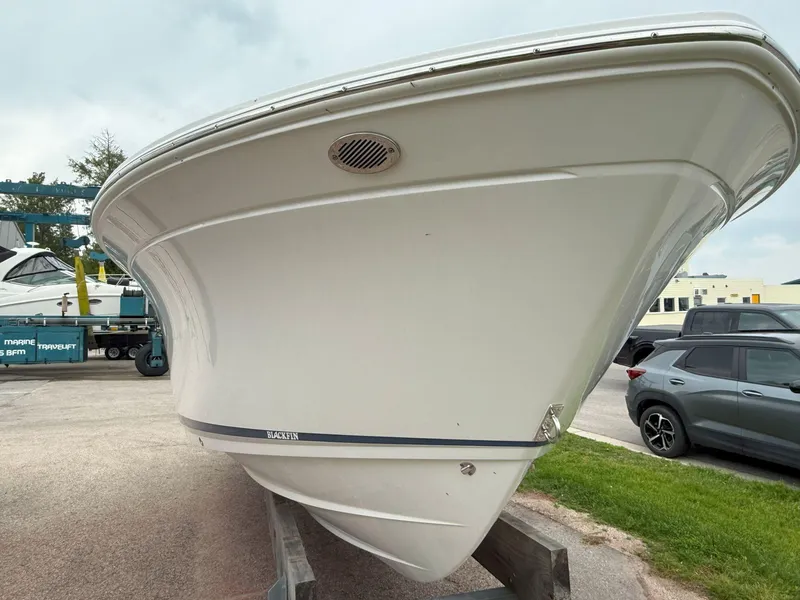Slide: The Image of 2026 Blackfin 232 DC boat on display, front view, parked outdoors. - 4