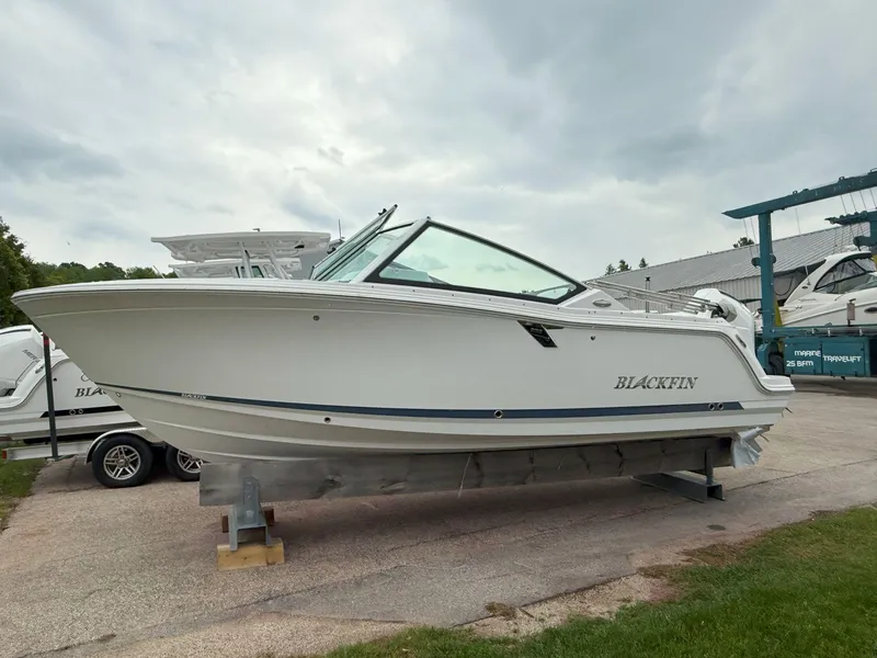 Slide: The Image of 2026 Blackfin 232 DC boat on display, side view, outdoors. - 5