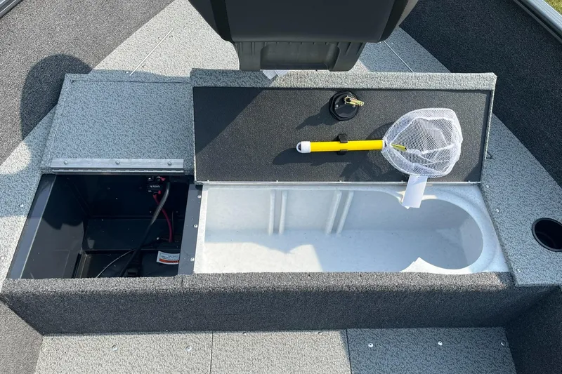 Slide: The Image of 2026 Lund 1650 Rebel XL Tiller boat interior with storage compartments and fishing net. - 10