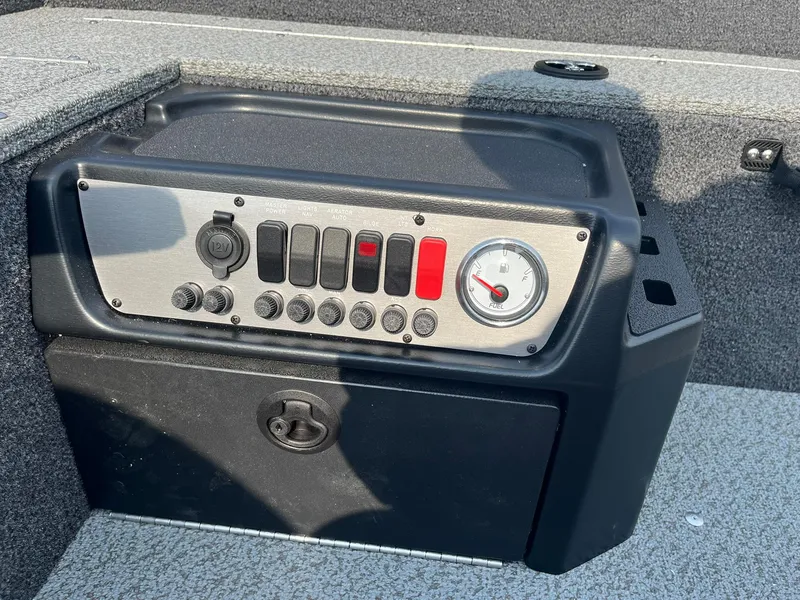 Slide: The Image of Control panel of 2026 Lund 1650 Rebel XL Tiller boat, featuring switches and a gauge. - 14