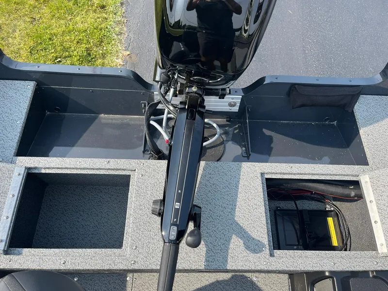 Slide: The Image of 2026 Lund 1650 Rebel XL Tiller boat interior with motor and storage compartments. - 15