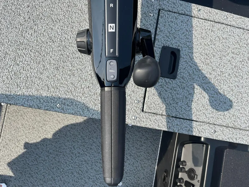 Slide: The Image of 2026 Lund 1650 Rebel XL Tiller control handle on textured boat floor. - 16