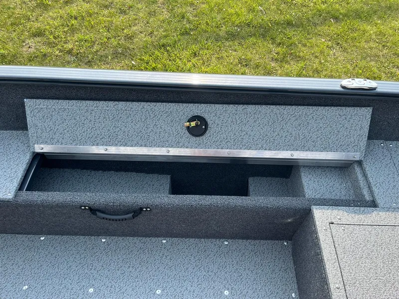 Slide: The Image of 2026 Lund 1650 Rebel XL Tiller boat interior with storage compartment open. - 20