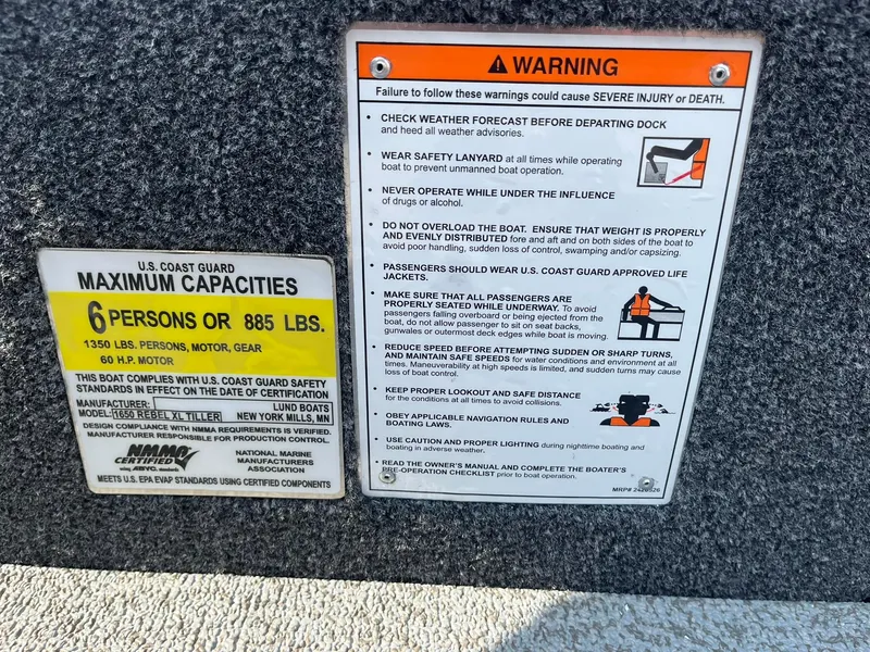 Slide: The Image of Warning and capacity labels on 2026 Lund 1650 Rebel XL Tiller boat, detailing safety guidelines. - 21