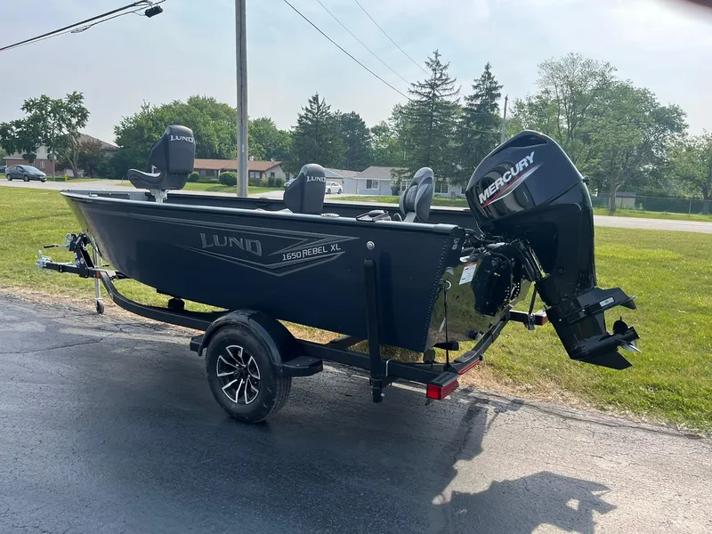Slide: The Image of 2026 Lund 1650 Rebel XL Tiller boat on trailer, featuring Mercury outboard motor. - 4