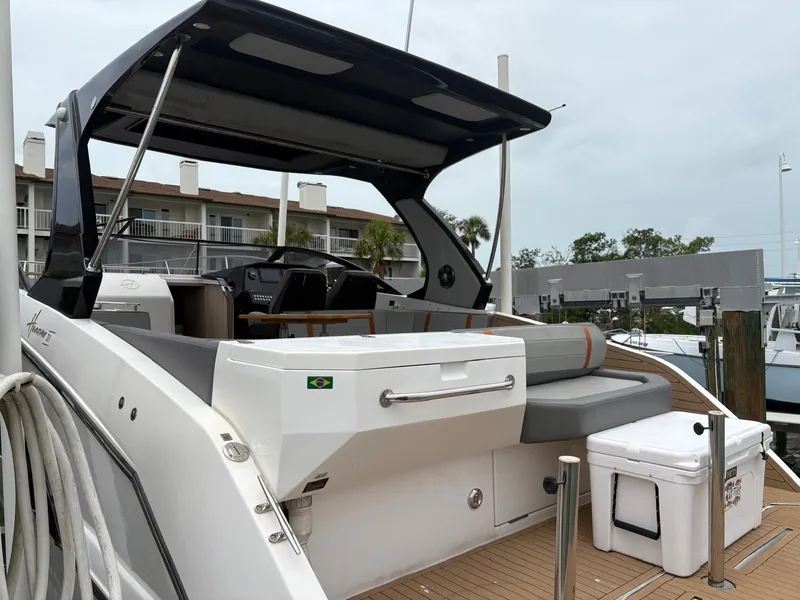 Slide: The Image of 2023 Hanover 377 boat with sleek design, docked at marina, featuring spacious seating area. - 22