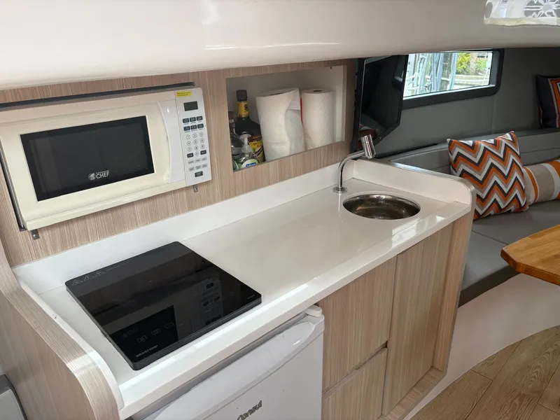 Slide: The Image of Modern kitchen in 2023 Hanover 377 boat with microwave, sink, and seating area. - 9