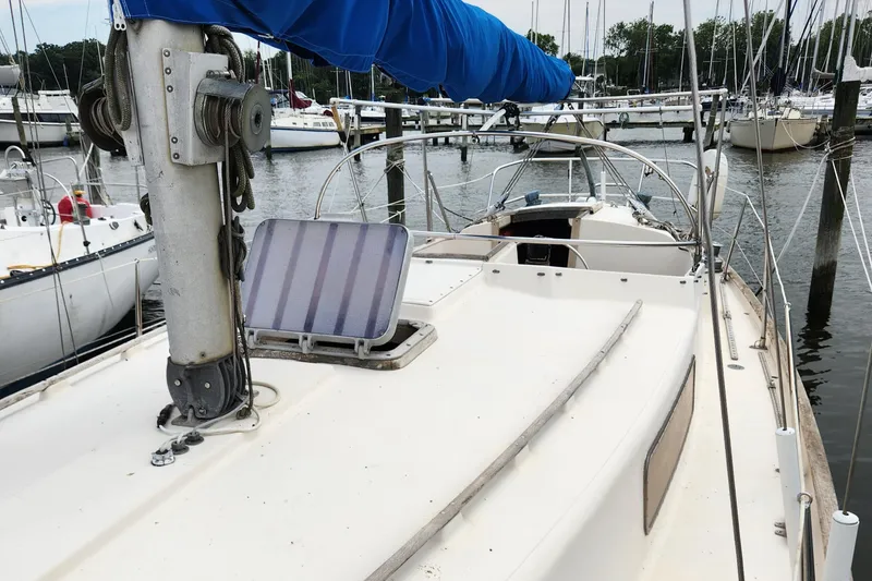Slide: The Image of 1974 Hallberg-Rassy Rasmus 35 sailboat docked at a marina, featuring a blue sail cover. - 10