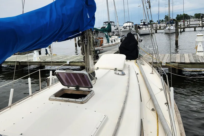 Slide: The Image of 1974 Hallberg-Rassy Rasmus 35 sailboat docked at a marina, featuring a blue sail cover. - 16