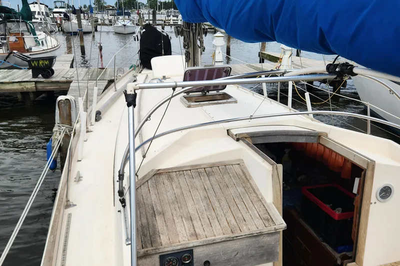 Slide: The Image of 1974 Hallberg-Rassy Rasmus 35 sailboat docked at a marina, featuring a blue sail cover. - 17