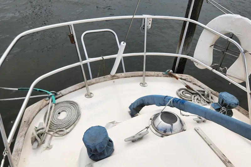 Slide: The Image of 1974 Hallberg-Rassy Rasmus 35 sailboat deck with ropes and railing by the water. - 26