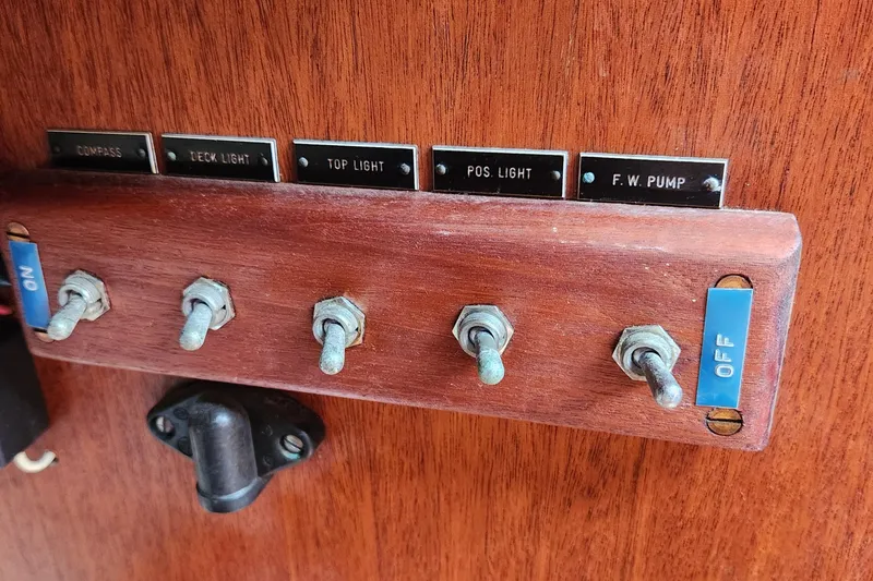 Slide: The Image of Control panel of a 1974 Hallberg-Rassy Rasmus 35 sailboat with labeled switches. - 42