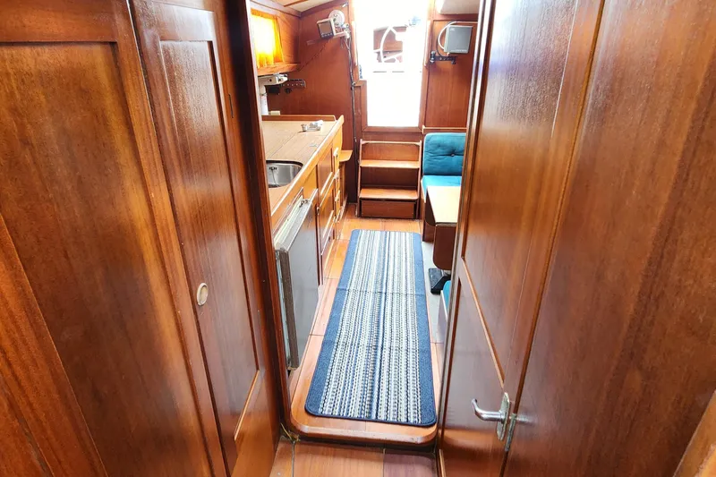 Slide: The Image of 1974 Hallberg-Rassy Rasmus 35 yacht interior with wooden cabinetry and compact kitchen. - 46