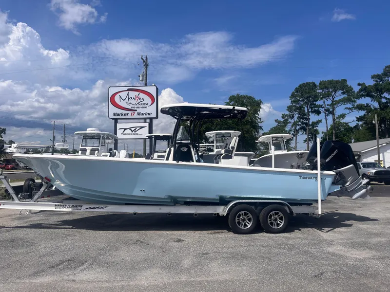 The Image of 2023 Tidewater 2700 Carolina Bay boat on trailer at marina under blue sky. - 0