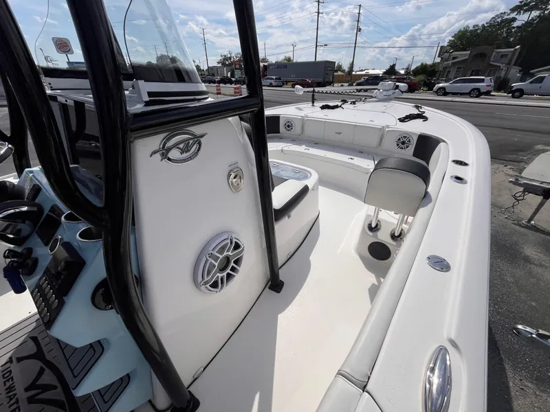 Slide: The Image of 2023 Tidewater 2700 Carolina Bay boat interior with console and seating, parked outdoors. - 11
