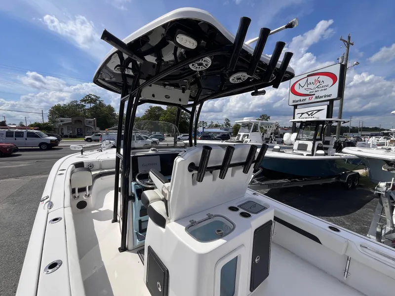 Slide: The Image of 2023 Tidewater 2700 Carolina Bay boat with T-top and rod holders at a marina. - 18