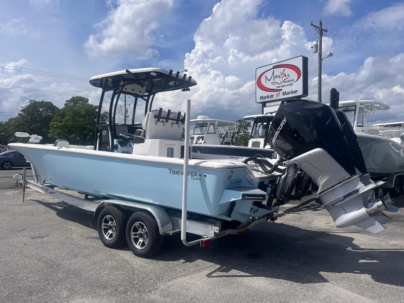 Slide: The Image of 2023 Tidewater 2700 Carolina Bay boat on trailer, displayed outdoors under cloudy sky. - 2