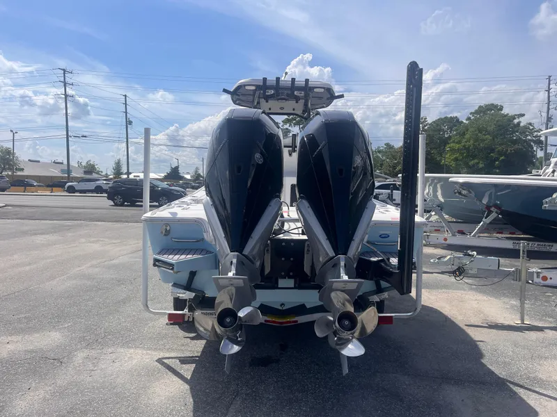 Slide: The Image of 2023 Tidewater 2700 Carolina Bay boat with dual outboard motors, parked outdoors. - 3