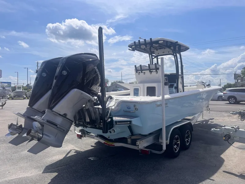 Slide: The Image of 2023 Tidewater 2700 Carolina Bay boat on trailer, featuring dual outboard motors. - 4