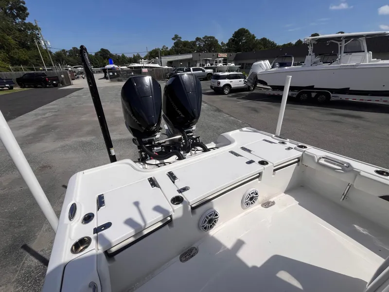 Slide: The Image of 2023 Tidewater 2700 Carolina Bay boat with dual engines, parked in a marina. - 5