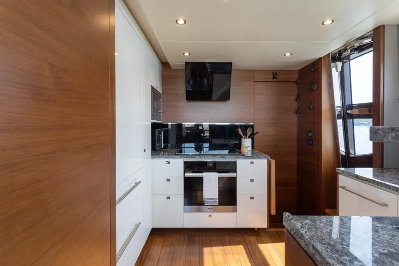 Slide: The Image of Luxurious kitchen interior of 2019 Princess Y88 Motor Yacht with modern appliances and wood accents. - 11