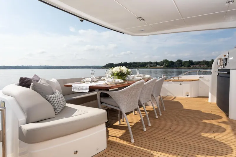 Slide: The Image of Luxurious 2019 Princess Y88 Motor Yacht deck with elegant dining setup and scenic water view. - 28