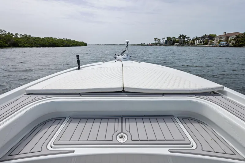 Slide: The Image of 2018 Barker Boatworks 26 Calibogue Bay on calm water, showcasing spacious deck and sleek design. - 10