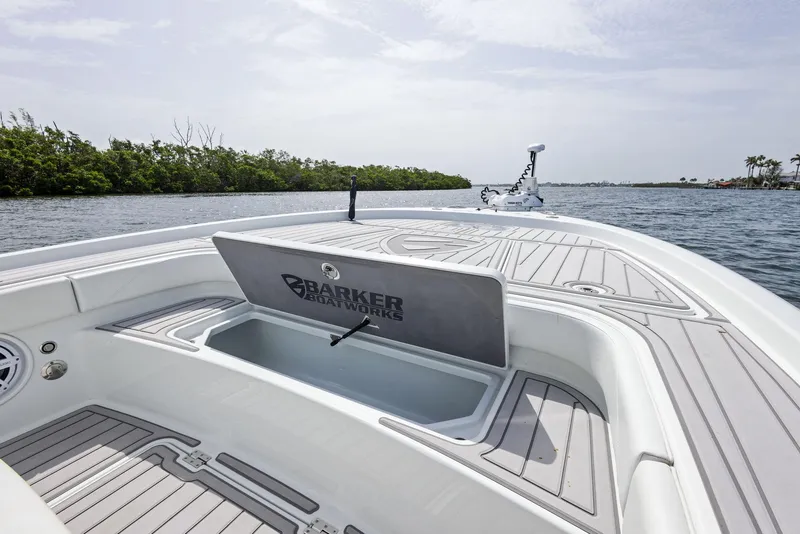 Slide: The Image of 2018 Barker Boatworks 26 Calibogue Bay on water, open storage compartment, sleek design. - 17