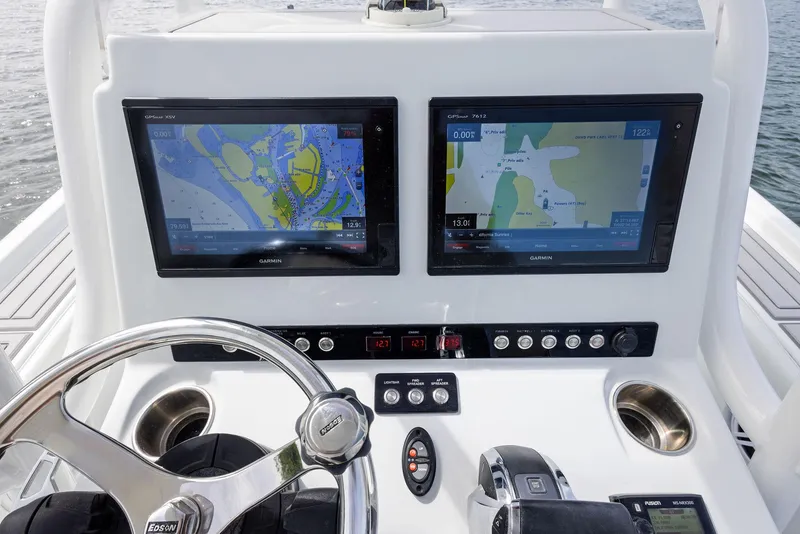 Slide: The Image of 2018 Barker Boatworks 26 Calibogue Bay helm with dual navigation screens and steering wheel. - 26