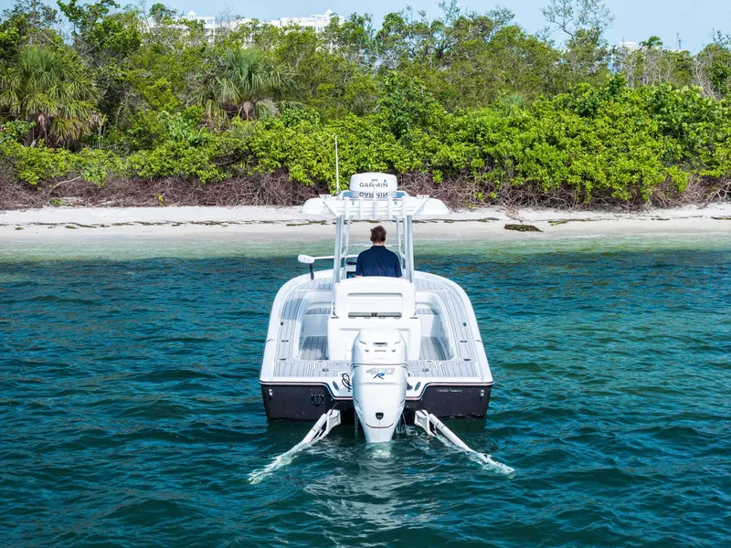 Slide: The Image of 2018 Barker Boatworks 26 Calibogue Bay on clear water near a lush shoreline. - 9