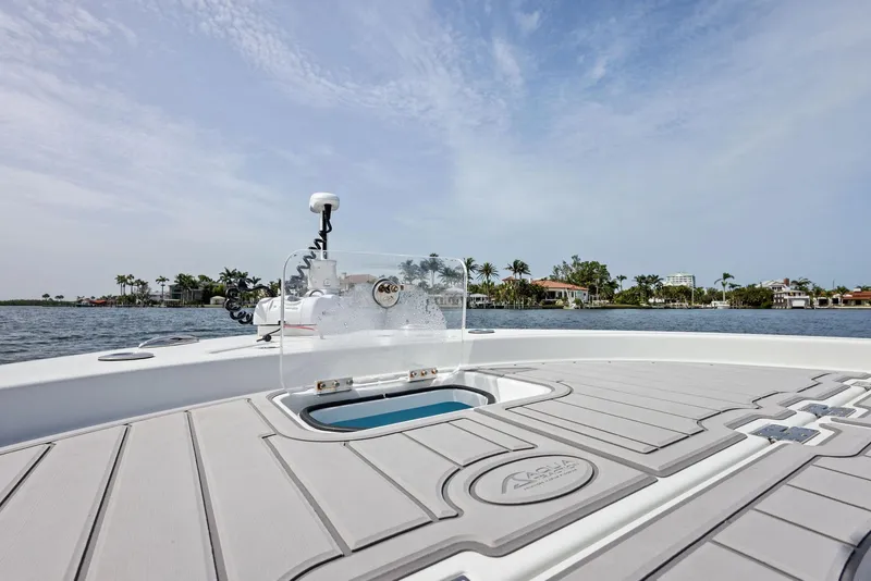 Slide: The Image of 2018 Barker Boatworks 26 Calibogue Bay on water, featuring spacious deck and clear sky. - 11