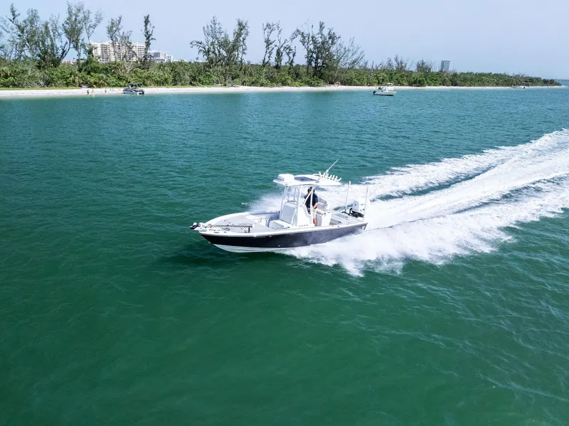 Slide: The Image of 2018 Barker Boatworks 26 Calibogue Bay cruising on clear blue water near a lush shoreline. - 45