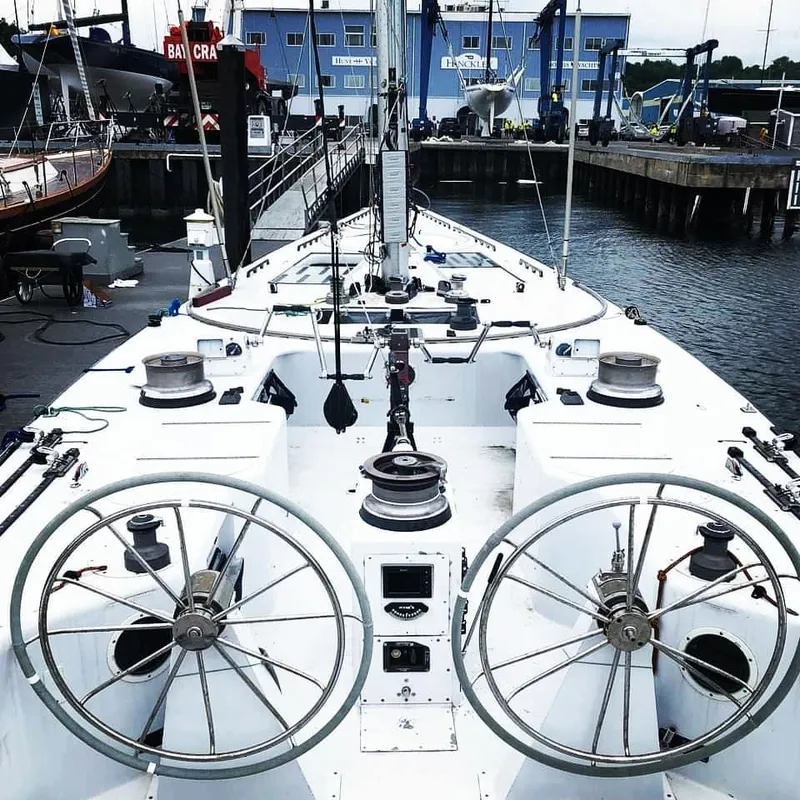 Slide: The Image of 1982 Sailboat 12 Meter model docked, featuring dual steering wheels and marina backdrop. - 6