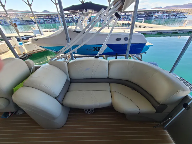Slide: The Image of 2018 Starcraft 24 CXE Tritoon with beige seating, docked at a marina. - 11