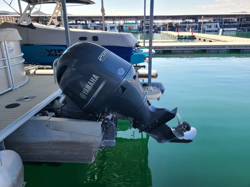 Slide: The Image of 2018 Starcraft 24 CXE Tritoon with Yamaha 200 outboard motor docked at marina. - 12