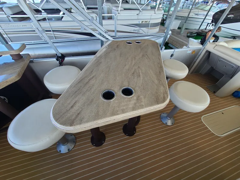 Slide: The Image of 2018 Starcraft 24 CXE Tritoon interior with table and seating arrangement. - 9