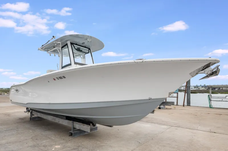 Slide: The Image of 2022 Sea Hunt Gamefish 27CE boat on a dock under a clear blue sky. - 1