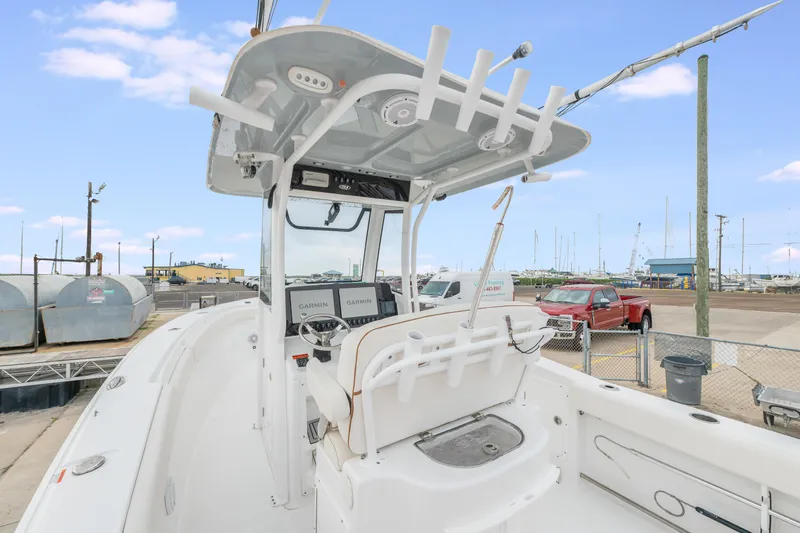 Slide: The Image of 2022 Sea Hunt Gamefish 27CE boat interior with helm and seating, docked at marina. - 13
