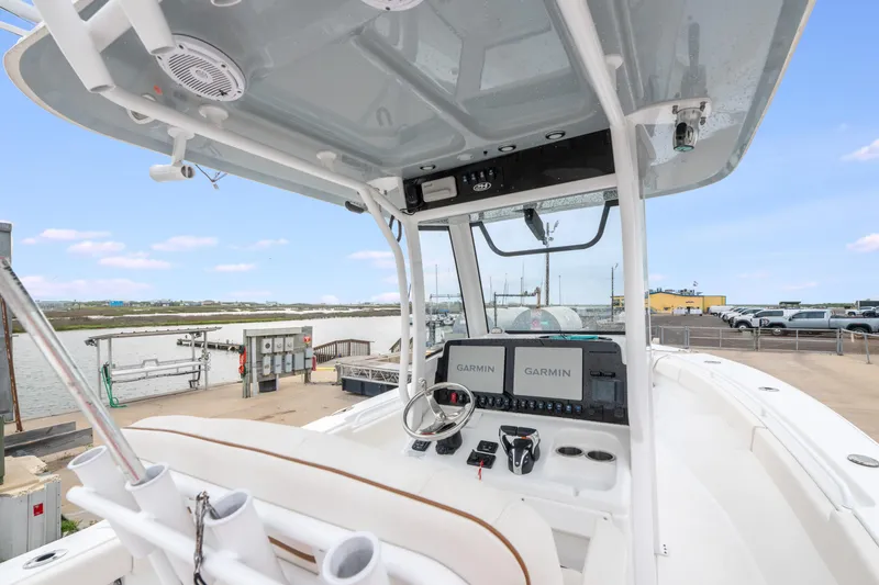 Slide: The Image of 2022 Sea Hunt Gamefish 27CE boat dashboard with Garmin displays at a marina. - 17