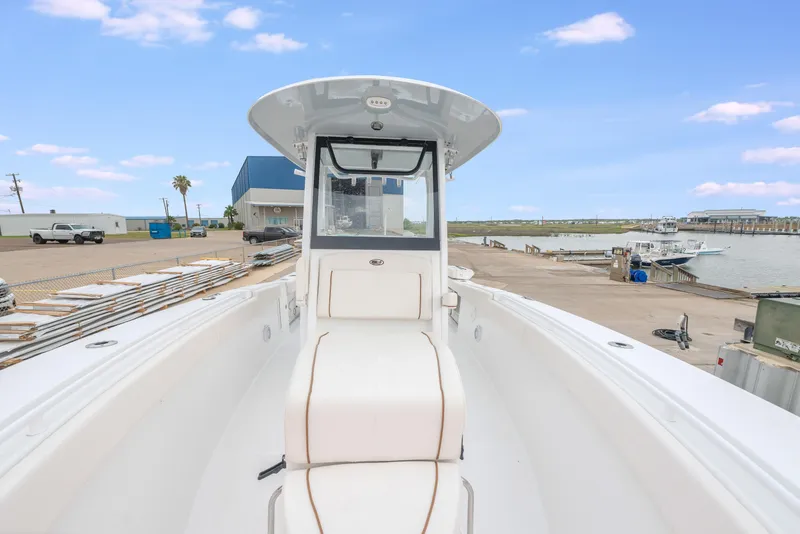 Slide: The Image of 2022 Sea Hunt Gamefish 27CE boat docked at marina, clear sky background. - 19