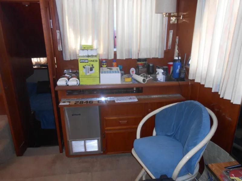 Slide: The Image of 1981 Uniflite Cabin Cruiser interior with chair, mini fridge, and various items on counter. - 10