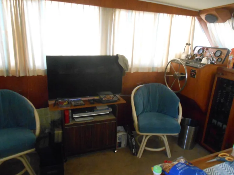 Slide: The Image of Interior of 1981 Uniflite Cabin Cruiser with TV, blue chairs, and steering wheel. - 11