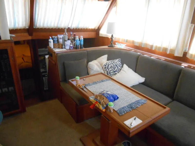 Slide: The Image of 1981 Uniflite Cabin Cruiser interior with cozy seating, table, and nautical decor. - 12