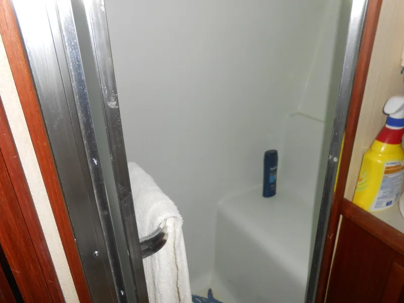 Slide: The Image of 1981 Uniflite Cabin Cruiser shower with towel and cleaning supplies. - 14